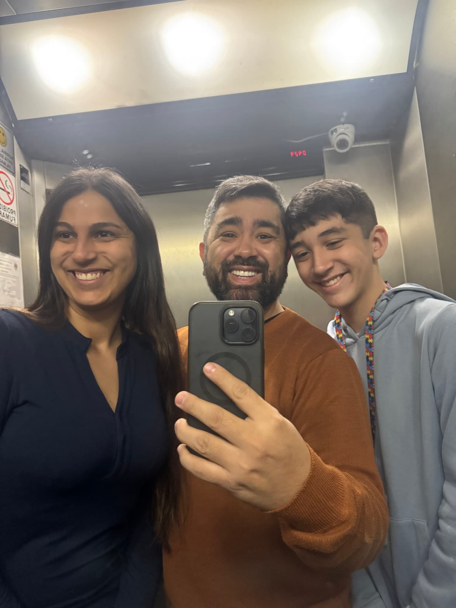 Tállia, Eduardo e Arthur juntos no espelho do elevador